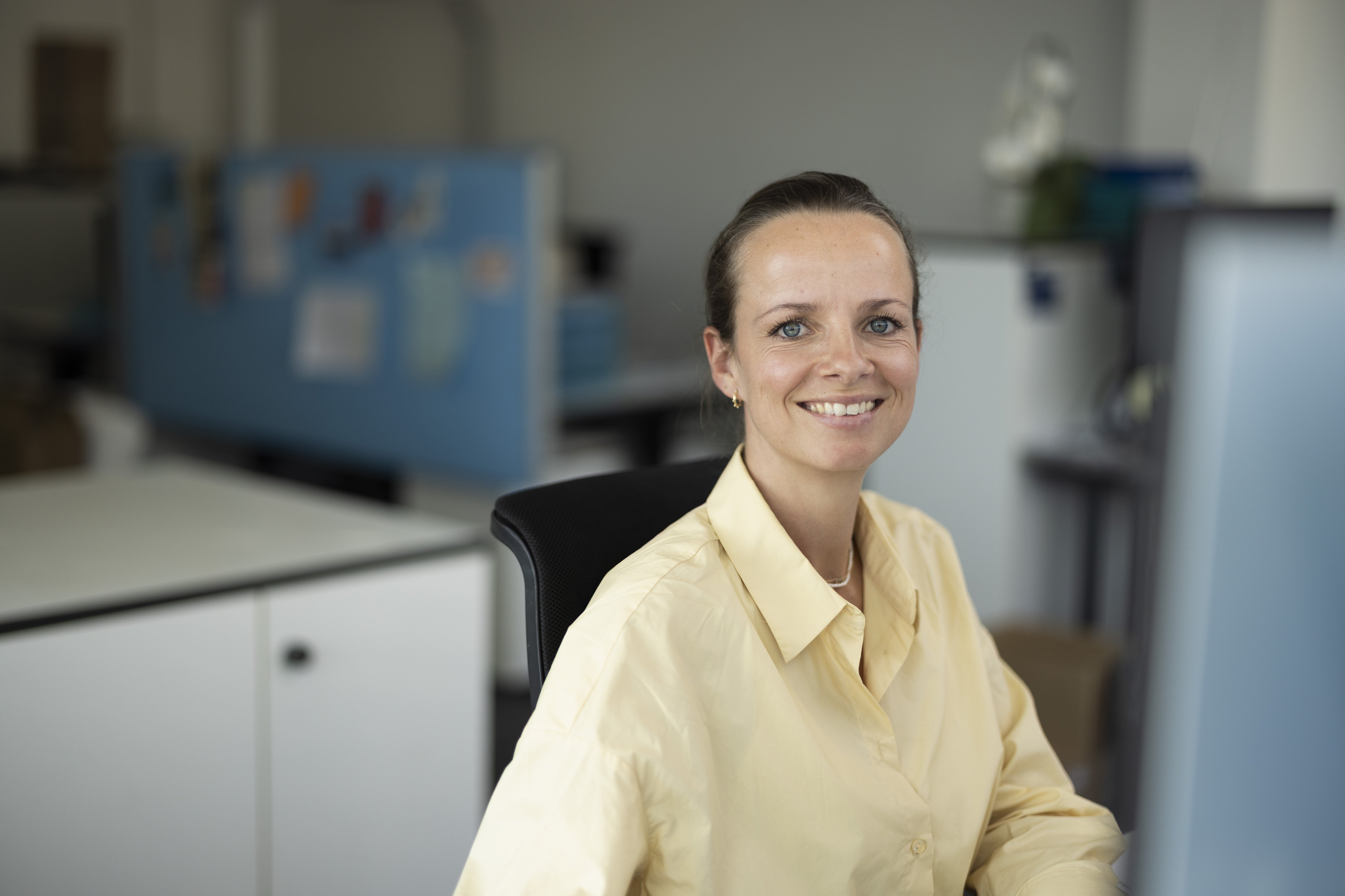 Portrait of Marcha working in the office, smiling at the camera