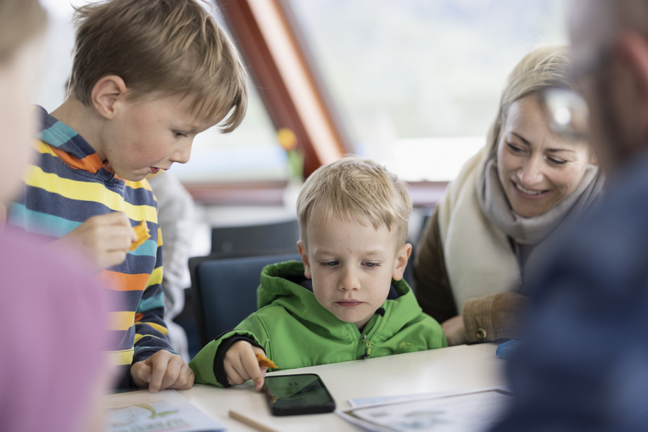 Kinder sitzen am Tisch mit Mutter