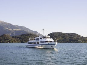 Motorschiff Rigi auf See fahrend mit Ufer im Hintergrund