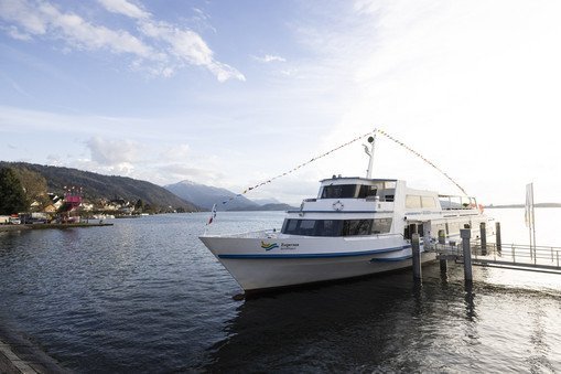 Ship stands at the jetty with a side view of the old town of Zug