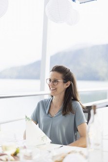 Porträt einer Mitarbeiterin sitzend am Tisch auf dem Aussendeck