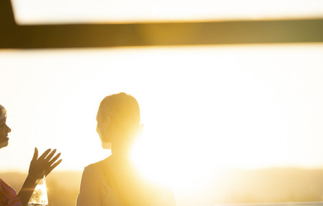 Silhoutte von Personen stehend im Sonnenuntergang