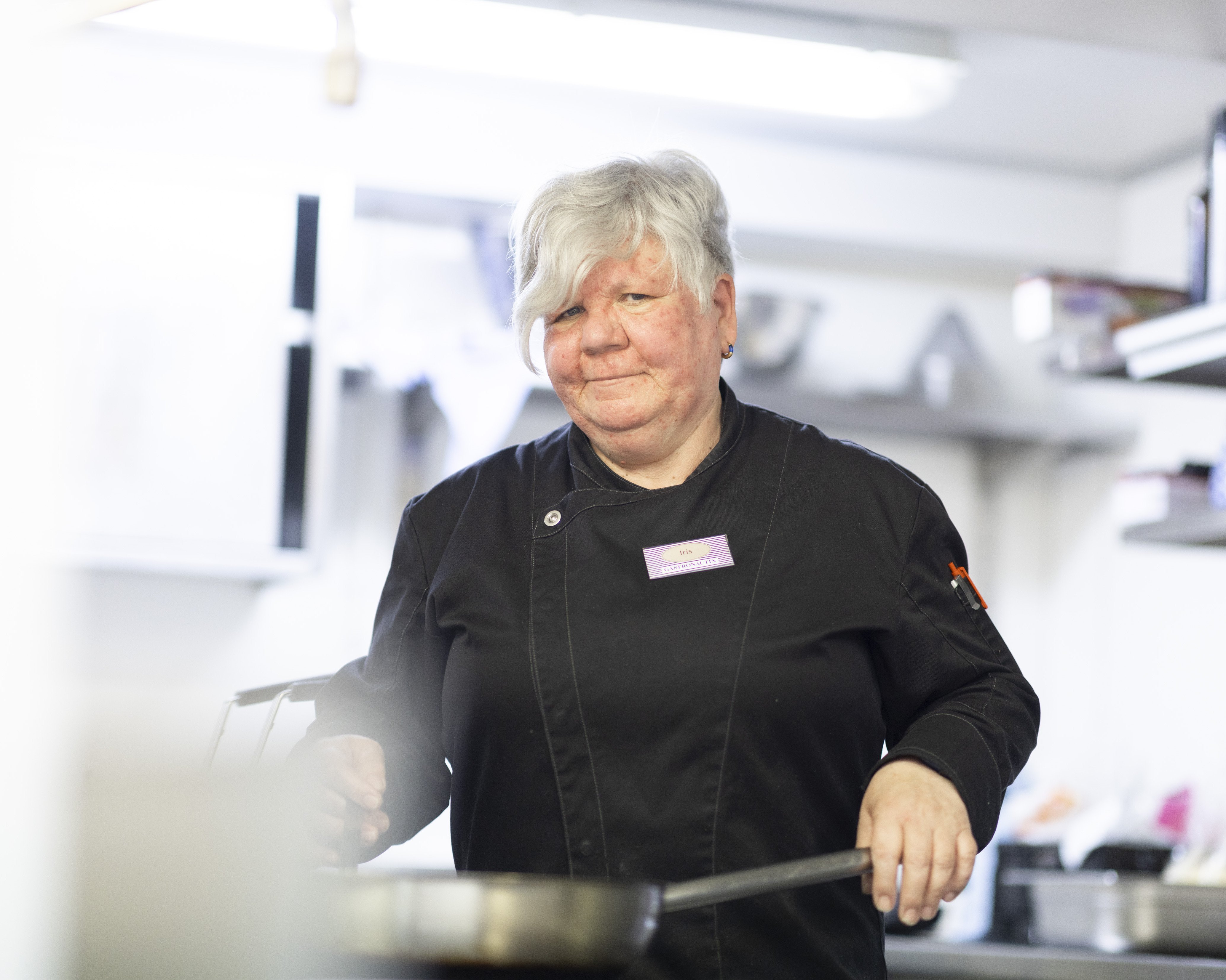 Köchin beim Kochen am Herd in der Schiffsküche