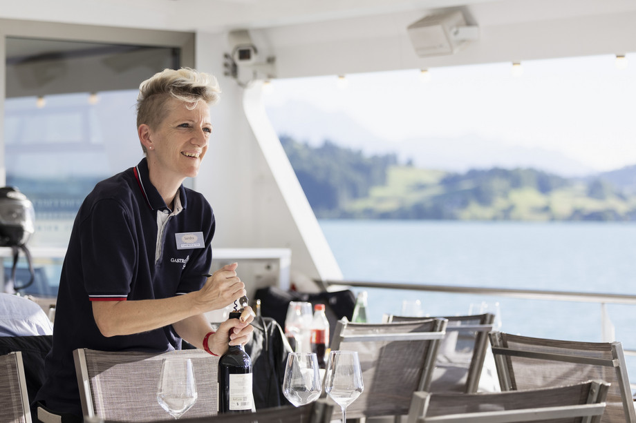 Chefin de Service am Öffnen einer Weinflasche