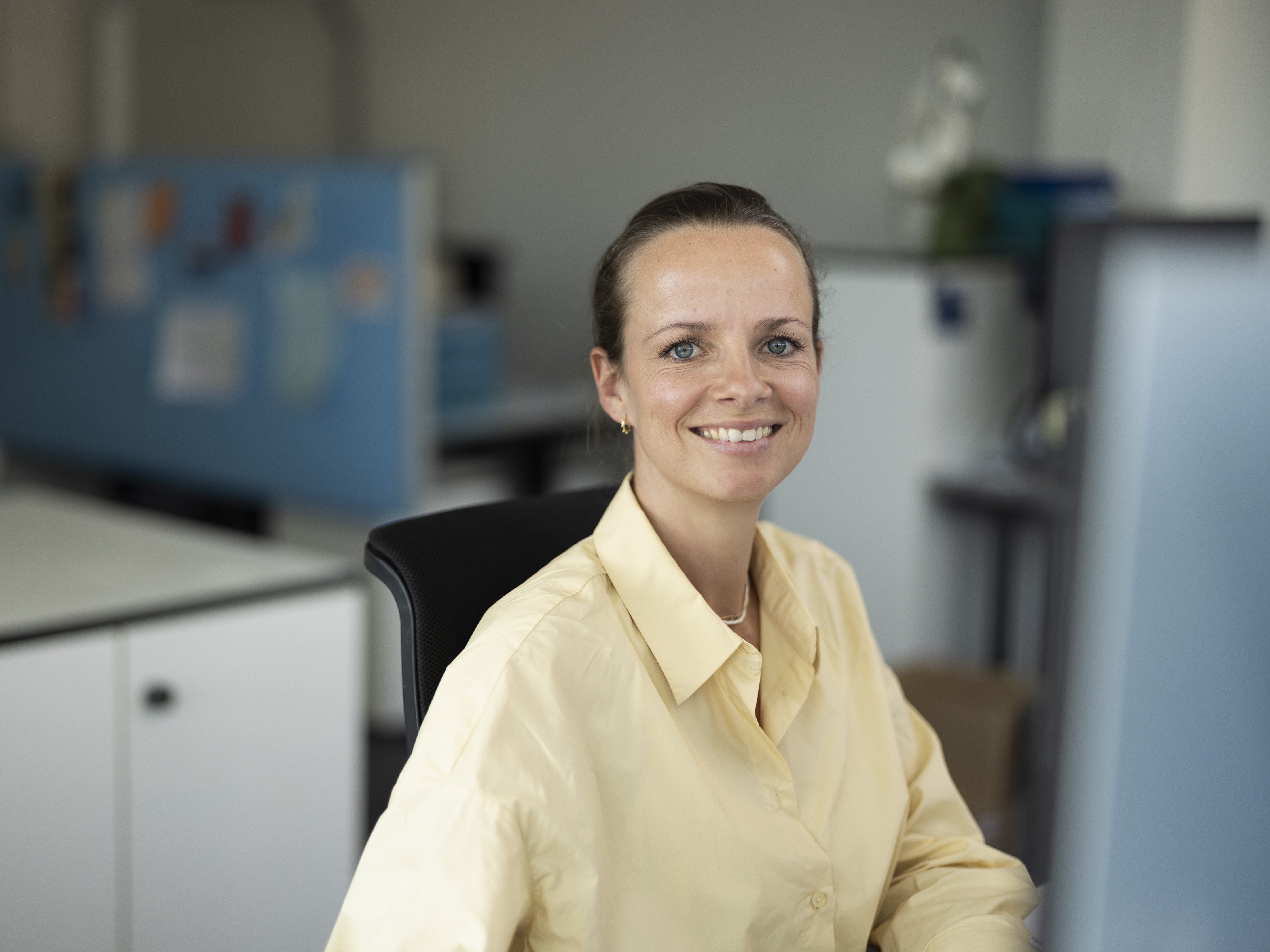 Portrait of Marcha working in the office, smiling at the camera