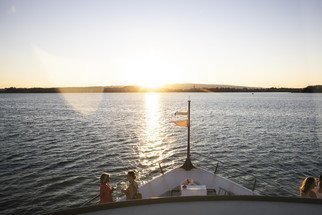 Abendstimmung auf dem See mit Blick auf den Bug mit Fahnen