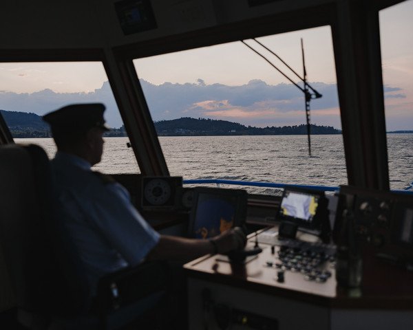 Schiffführer am Steuer auf einer Abendfahrt